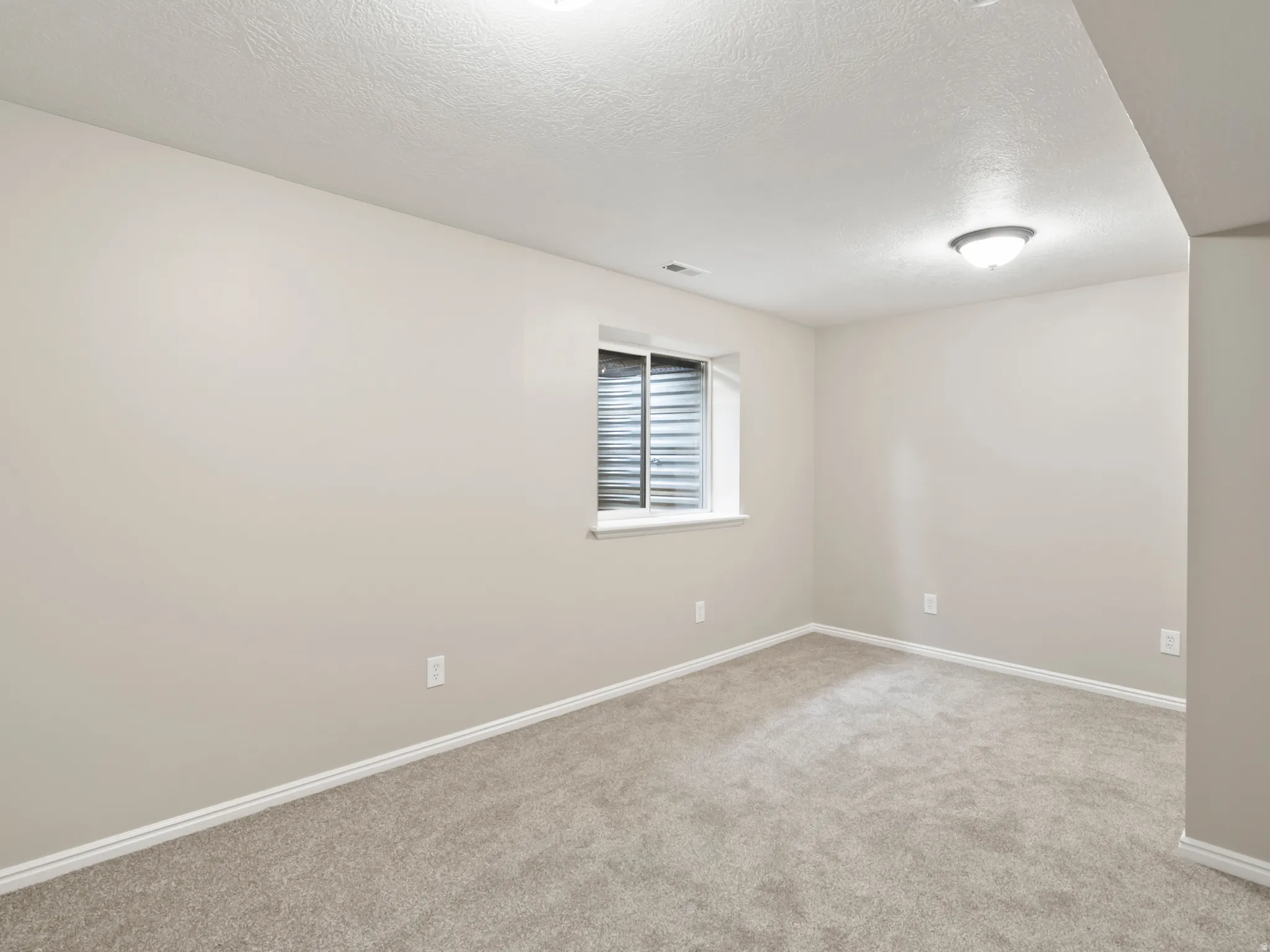 Room with light gray walls, white trim, and gray carpeting