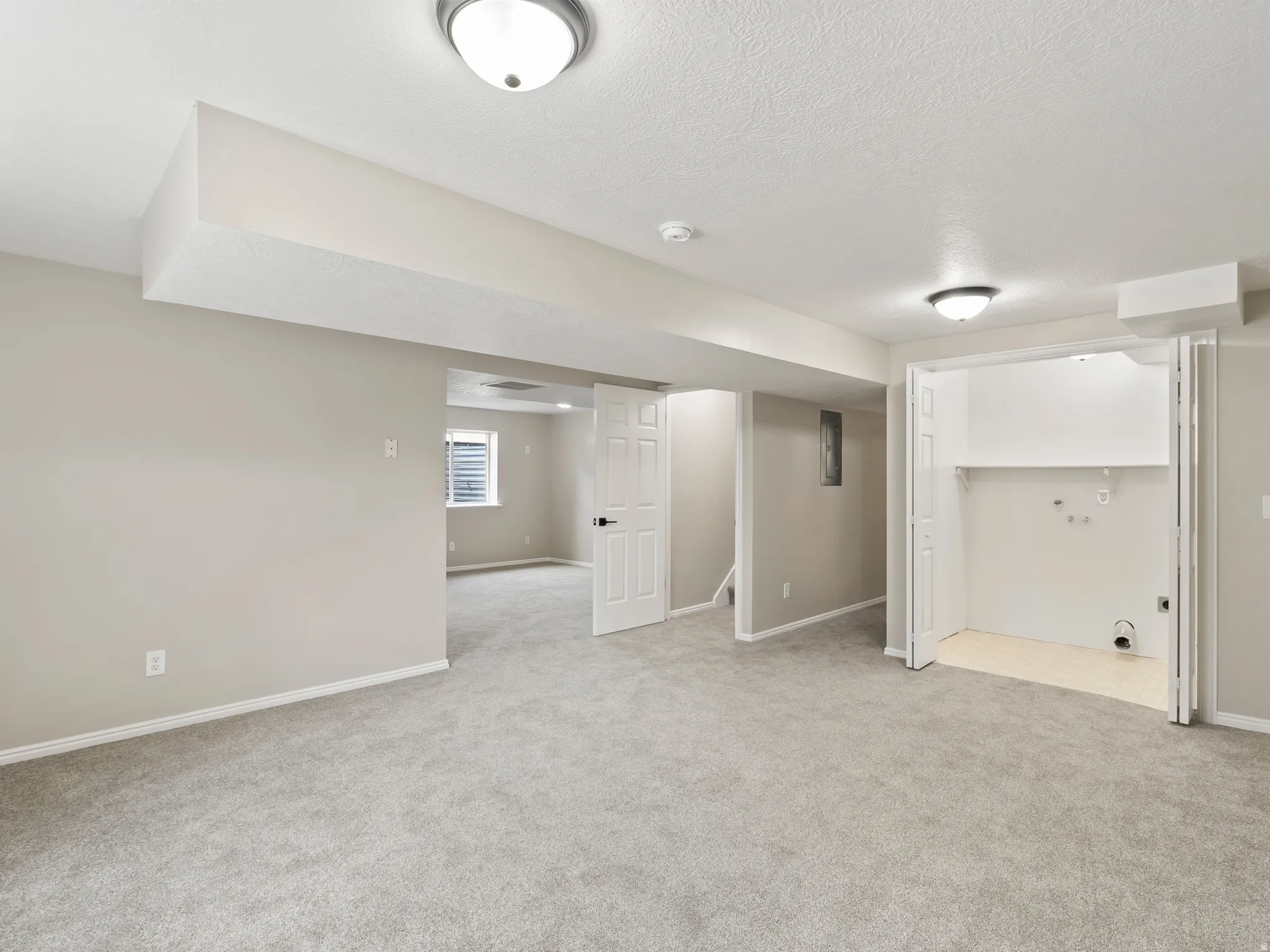 Spacious interior featuring neutral paint, light gray carpeting, and recessed lighting