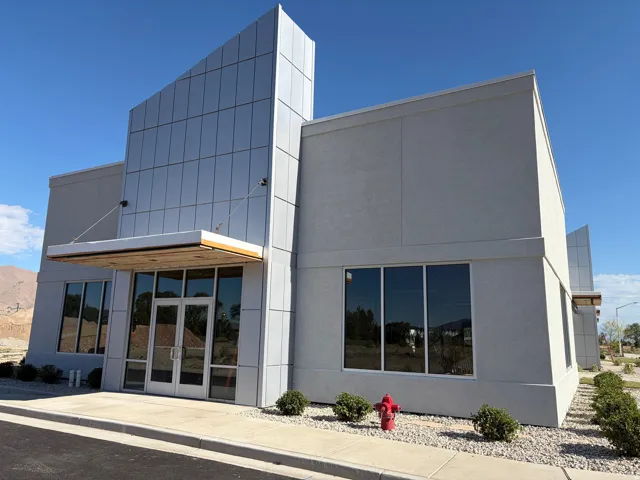 Modern commercial building featuring a stucco exterior and a prominent facade with reflective paneling