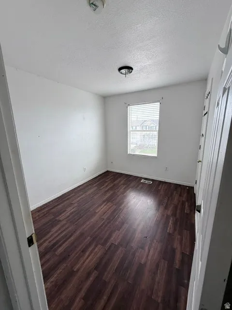 Room featuring wood-finish flooring and white walls