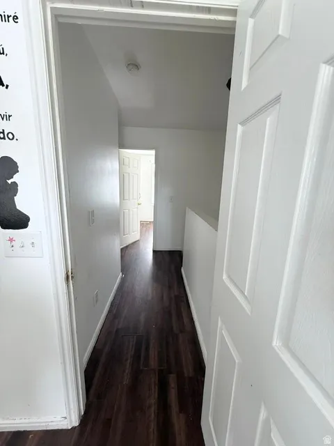 Hallway featuring wood-finish flooring and white paneled doors