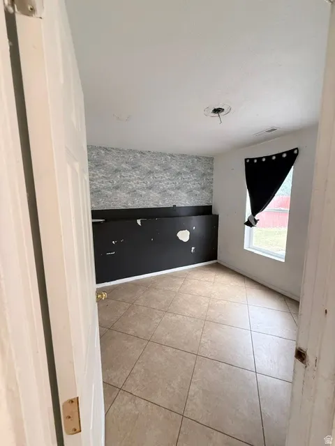 Neutral-toned tile flooring present throughout the room, complemented by a window providing natural light