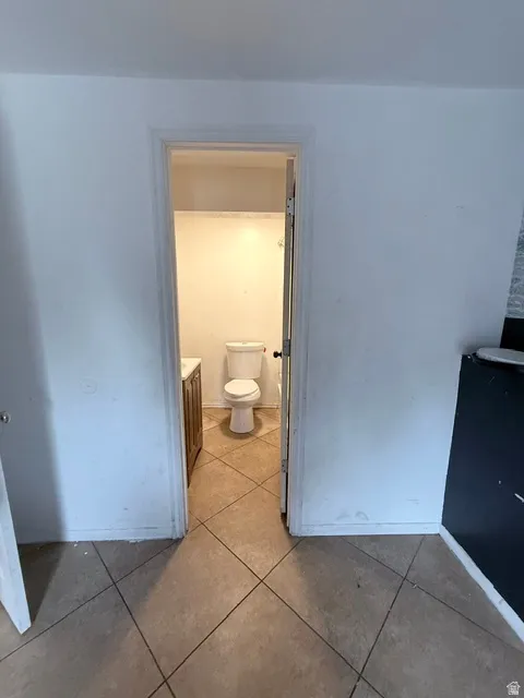 Bathroom featuring a wood-finish vanity with a white countertop and a white toilet
