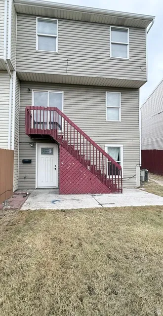 Two-story property featuring light-colored siding