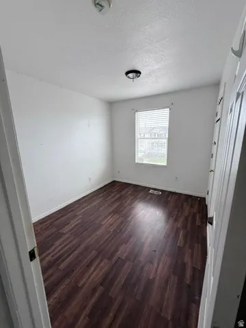 Room featuring wood-finish flooring and white walls