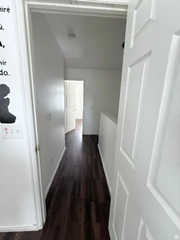 Hallway featuring wood-finish flooring and white paneled doors