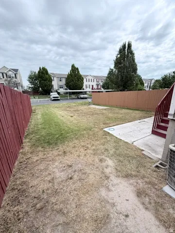 Private fenced yard featuring a concrete patio and red wood fencing