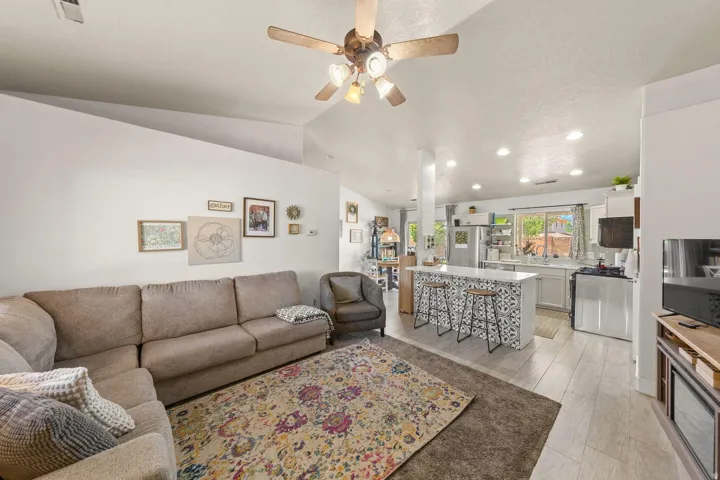 Open-concept living space featuring vaulted ceilings and a ceiling fan