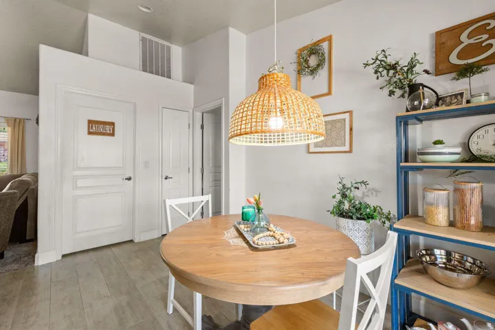 Dining area featuring wood-finish flooring, a woven pendant light fixture, and a built-in shelving unit