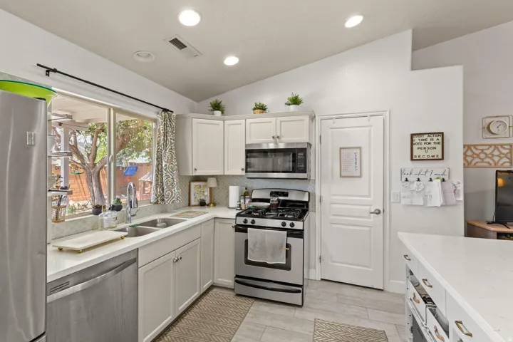 Kitchen featuring light-toned cabinetry, stainless steel appliances, and a double basin sink