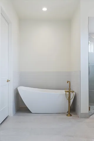 Freestanding bathtub with a floor-mounted brass faucet