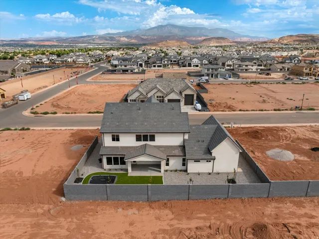 New construction residence with an enclosed backyard, featuring a covered patio, artificial turf, and a built-in trampoline