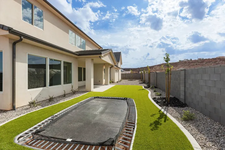 Exterior featuring stucco siding, multiple large windows, and a covered patio