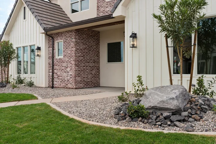 Exterior facade featuring contrasting board-and-batten siding and brickwork, a dark-toned tile roof, and a covered entry