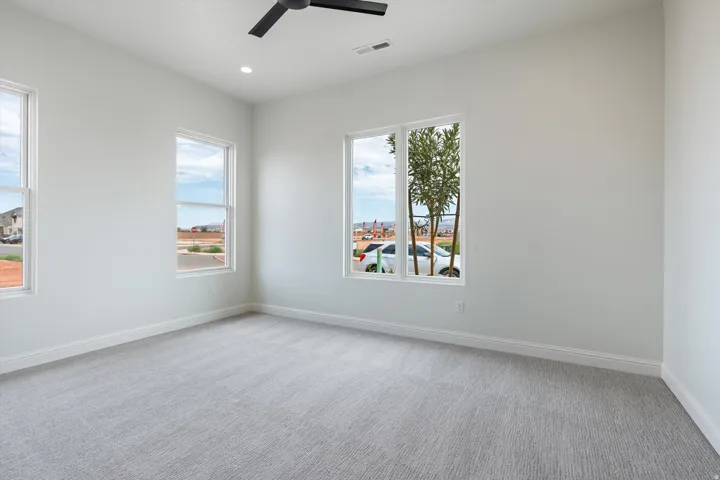 White walls with recessed lighting and a black ceiling fan