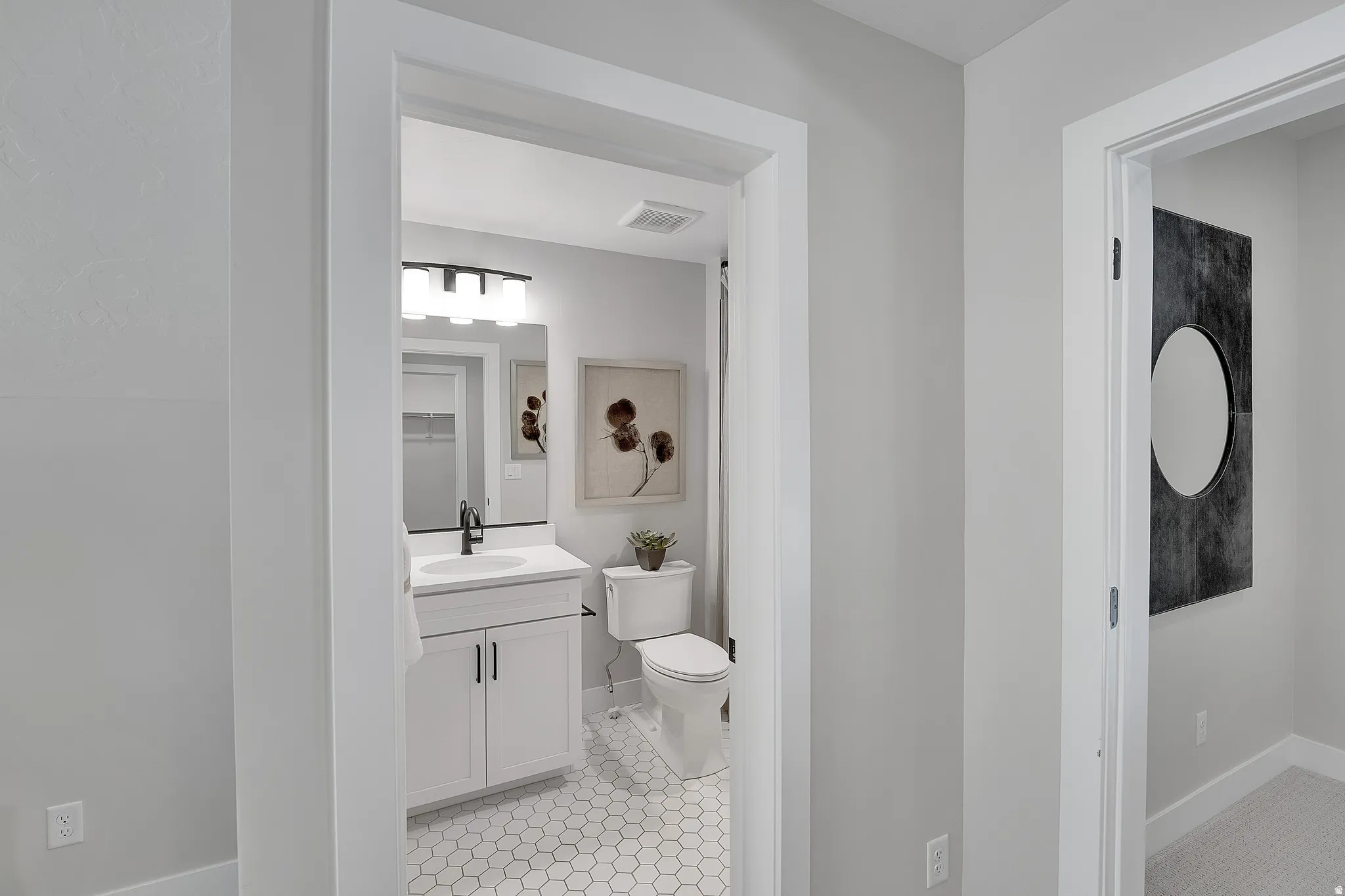 Bathroom featuring a white vanity with cabinet storage, a white countertop, and a rectangular undermount sink with a black faucet. This is not the actual home being built but a representation of the features available in this home. Colors and finishes may
