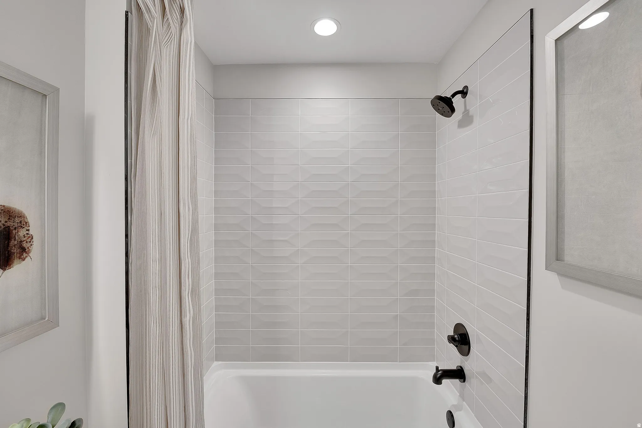 Tub and shower combination featuring black matte fixtures. This is not the actual home being built but a representation of the features available in this home. Colors and finishes may differ from those shown.