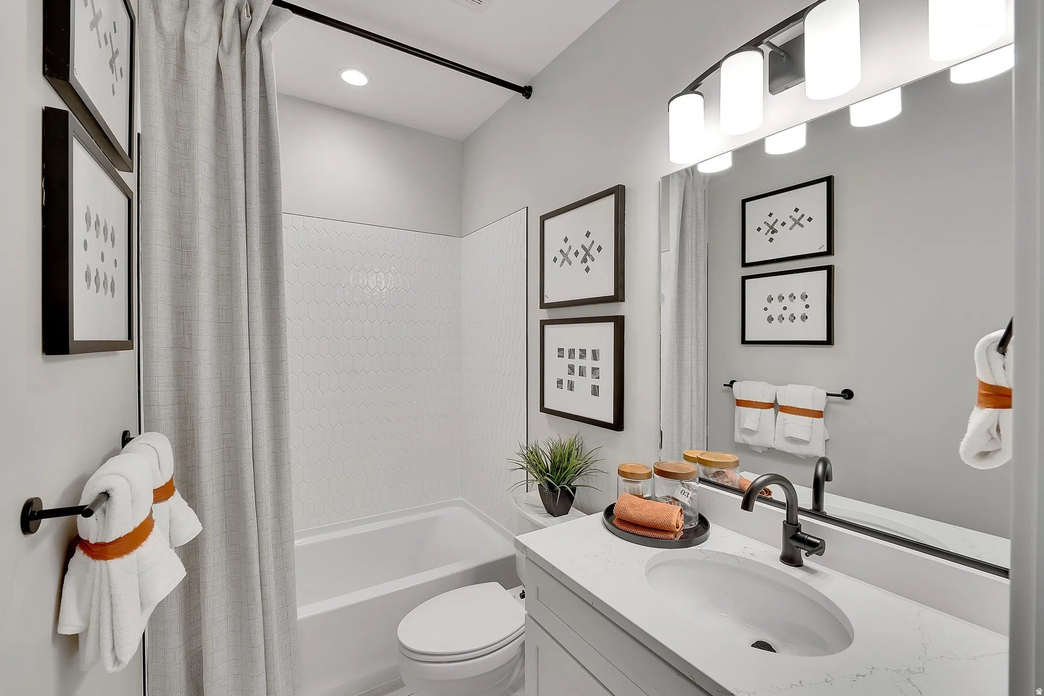 Bathroom featuring a tub and shower combination with white hexagonal tile surround. This is not the actual home being built but a representation of the features available in this home. Colors and finishes may differ from those shown.