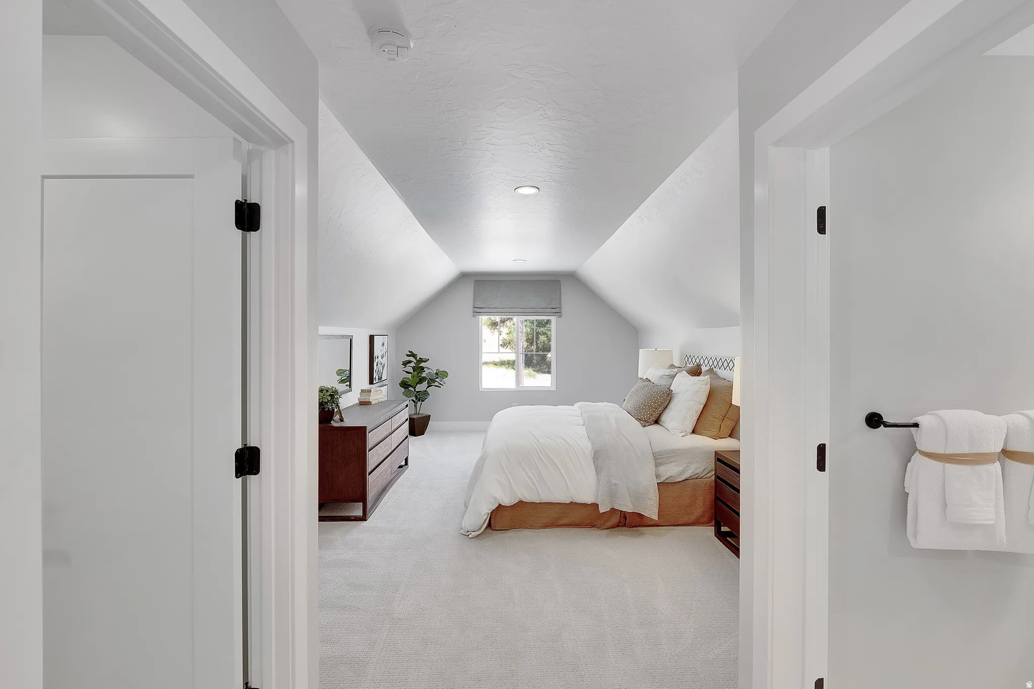 Attic bedroom featuring pitched ceilings, recessed lighting, a window with a roller shade, and light-toned carpeting. This is not the actual home being built but a representation of the features available in this home. Colors and finishes may differ from