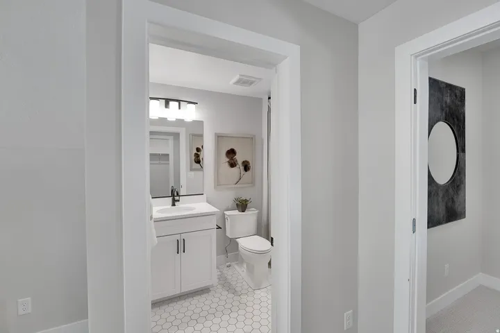 Bathroom featuring a white vanity with cabinet storage, a white countertop, and a rectangular undermount sink with a black faucet. This is not the actual home being built but a representation of the features available in this home. Colors and finishes may