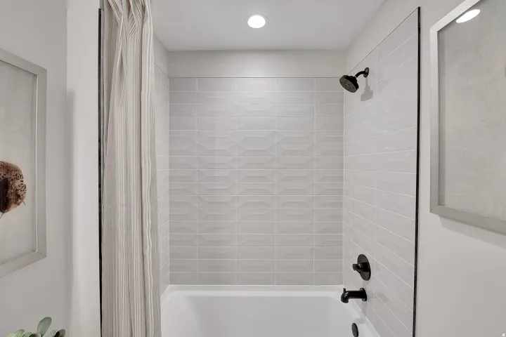 Tub and shower combination featuring black matte fixtures. This is not the actual home being built but a representation of the features available in this home. Colors and finishes may differ from those shown.