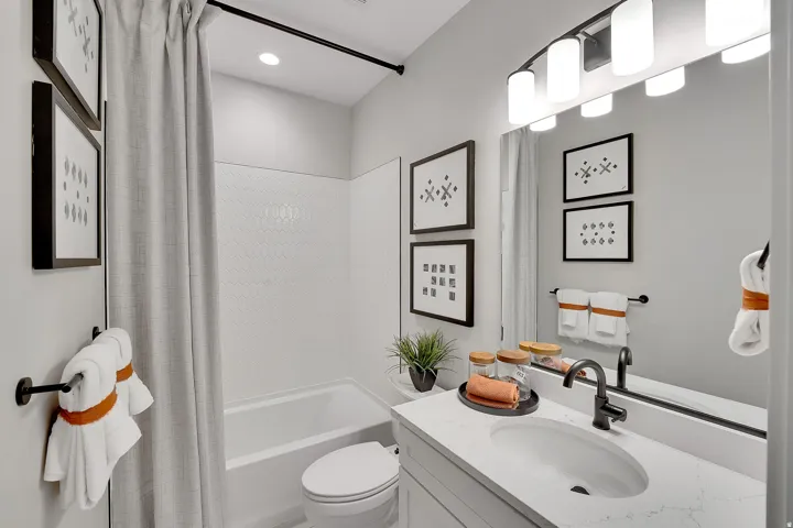 Bathroom featuring a tub and shower combination with white hexagonal tile surround. This is not the actual home being built but a representation of the features available in this home. Colors and finishes may differ from those shown.