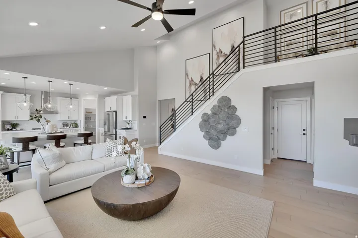 Open-concept living area featuring a vaulted ceiling and open rail. This is not the actual home being built but a representation of the features available in this home. Colors and finishes may differ from those shown. There will be a 1/2 pony wall instead