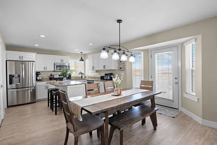 Open-concept kitchen and dining area featuring light-toned flooring and neutral wall tones
