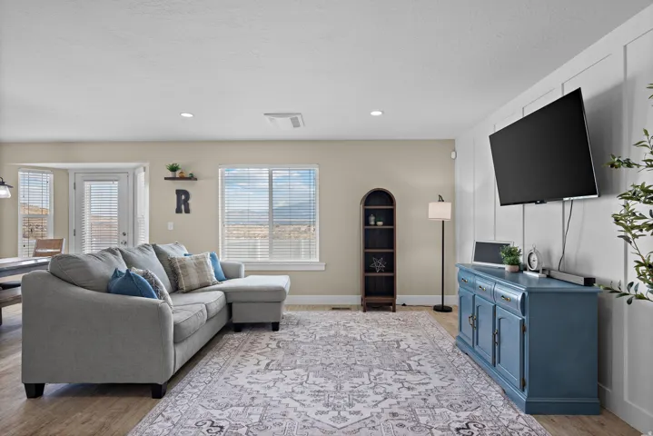 Spacious living area featuring wood-finish flooring, recessed lighting, and a prominent picture window