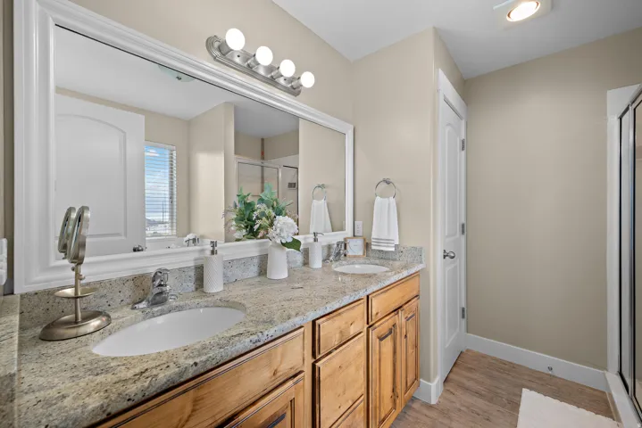 Dual vanity featuring granite-finish countertops, undermount sinks, and wood cabinetry