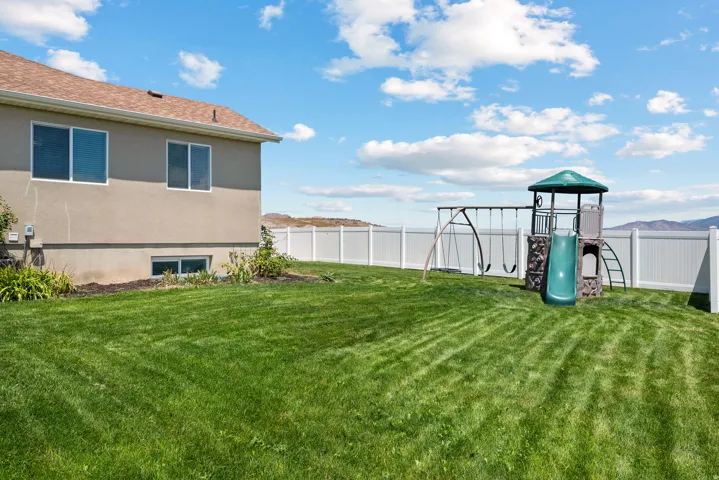 Expansive green lawn enclosed by a white privacy fence