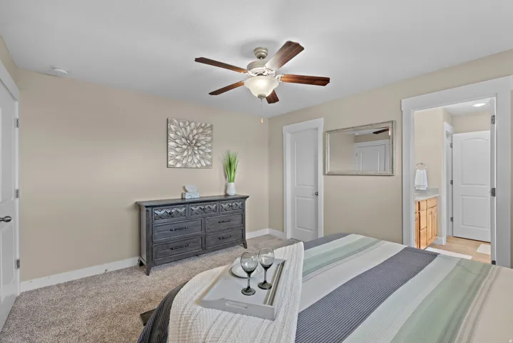 Carpeted room with a ceiling fan light fixture