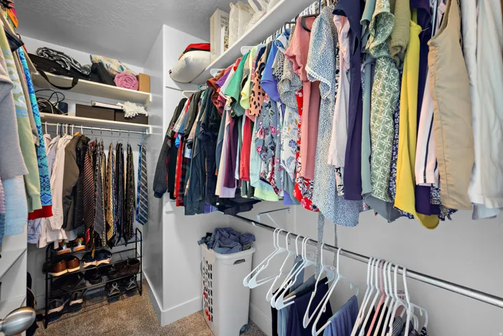 Spacious walk-in closet featuring multiple shelving units and hanging rods