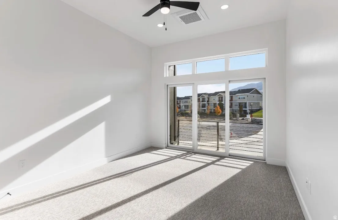 Spacious room with light gray carpet flooring and white walls