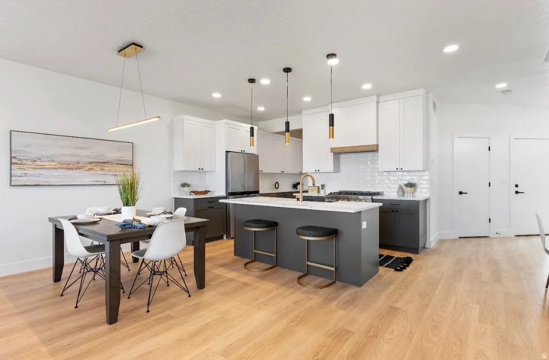 Open-concept kitchen and dining area with light wood-finish flooring