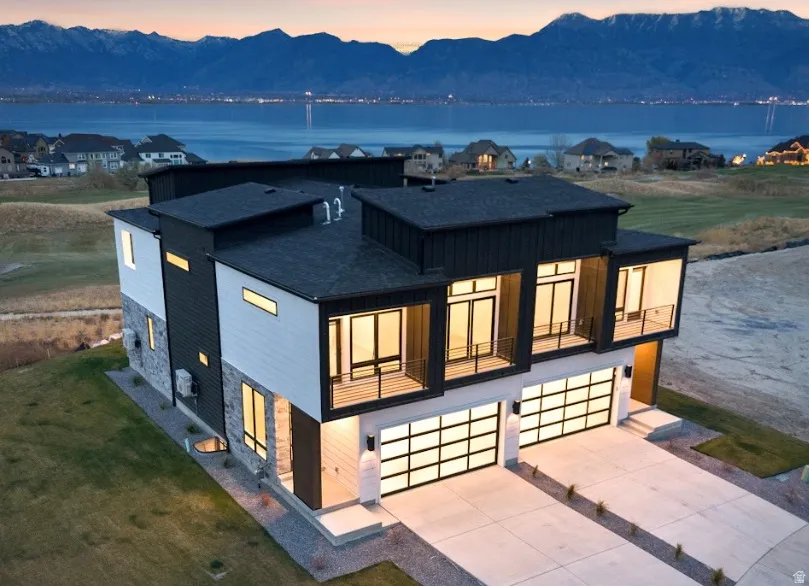 Modern architectural design featuring prominent balcony spaces and expansive glass-paneled garage doors