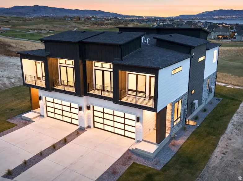 Modern exterior featuring mixed materials including dark siding, light paneling, and stone accents