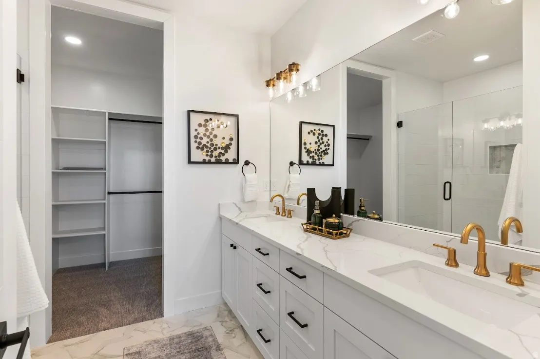 Dual vanity with integrated sinks, gold-finish fixtures, and a white countertop