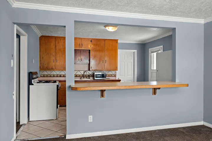 Kitchen pass-through with a light wood-finish breakfast bar