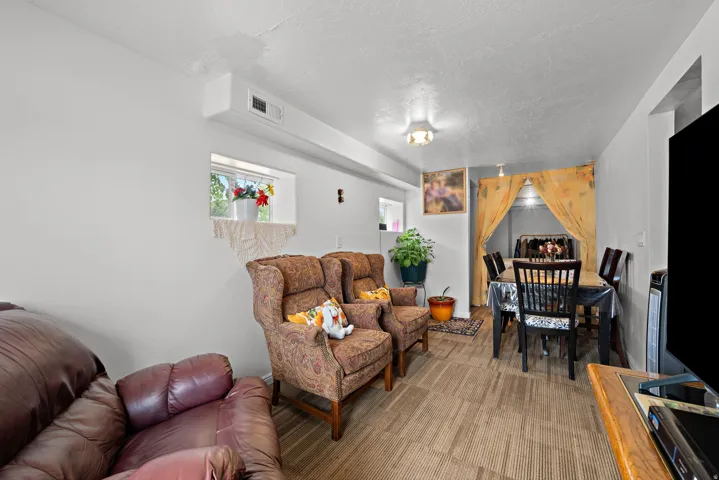 Carpeted living area with a recessed window and a defined dining space featuring wood-finish flooring