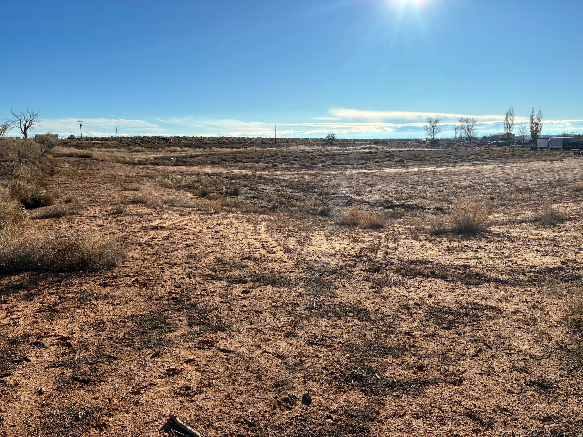 Expansive open terrain featuring arid ground cover and a vast horizon