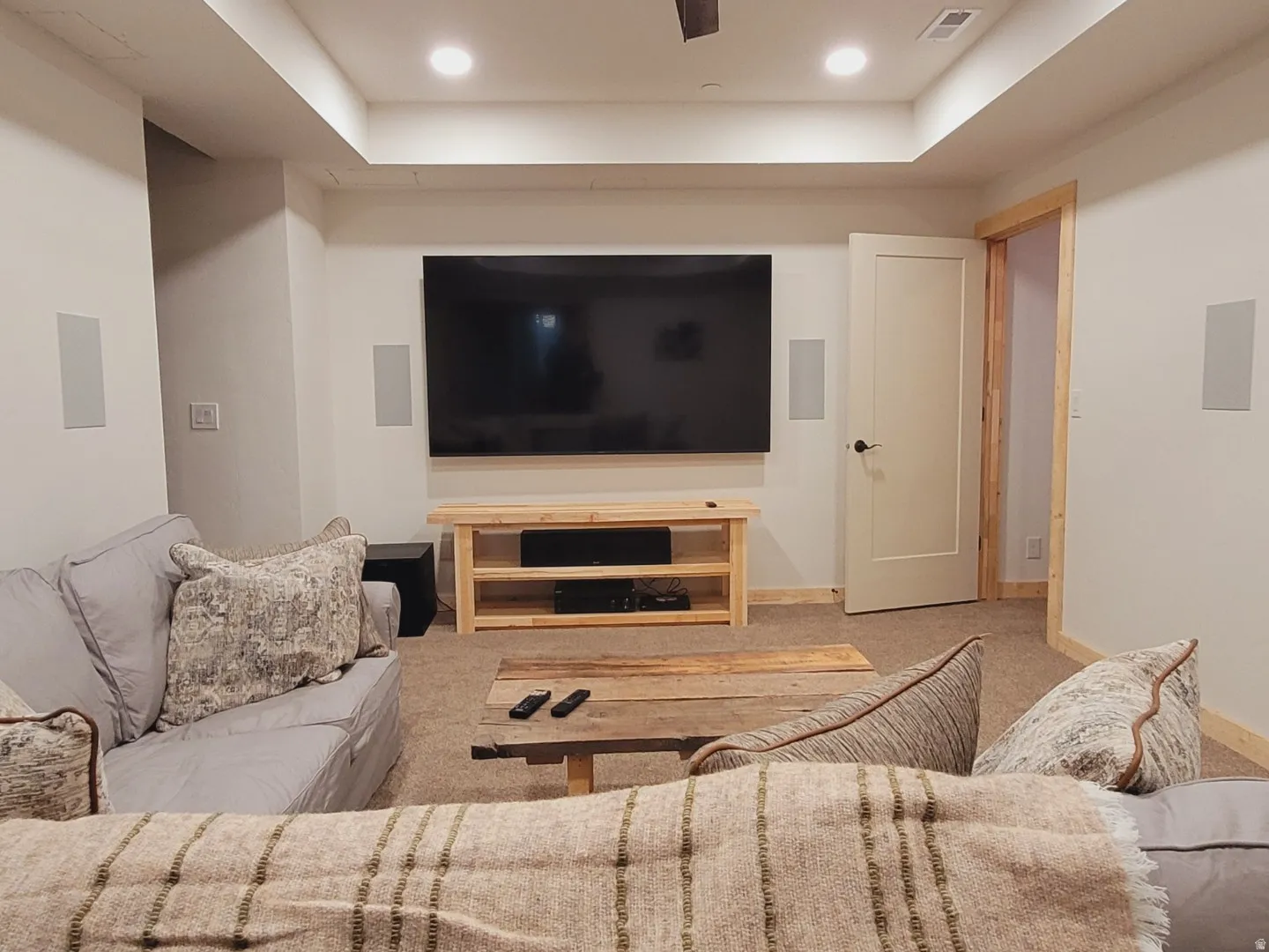 Carpeted entertainment space featuring recessed lighting, a modern ceiling fan, and built-in wall speakers