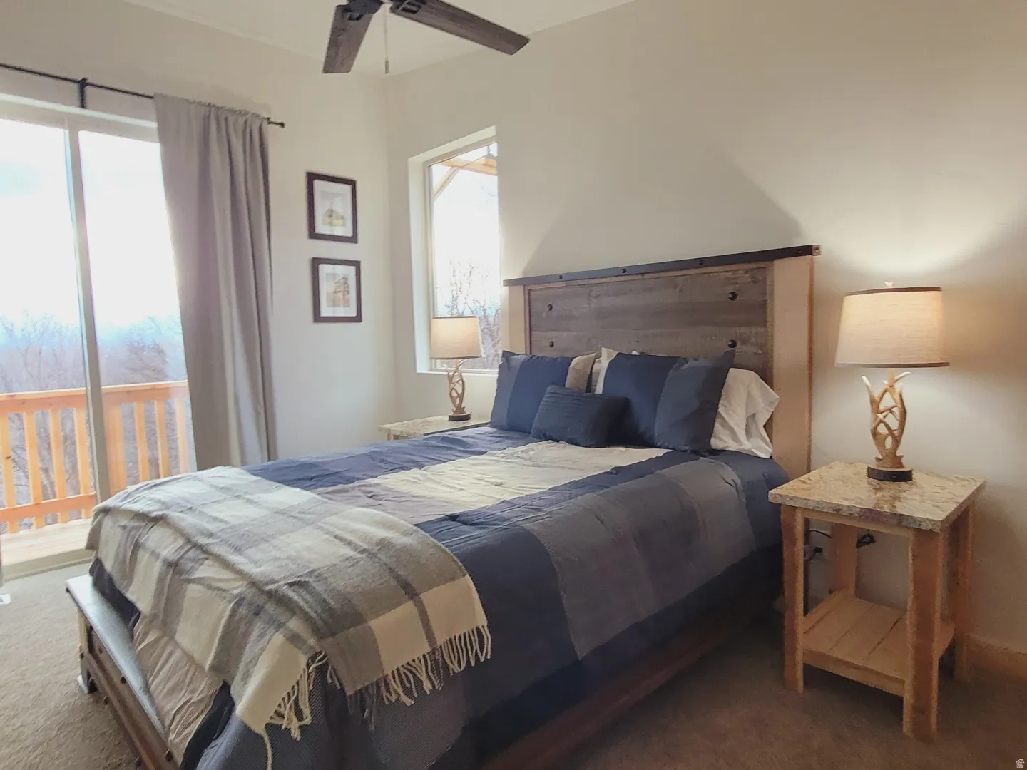 Spacious room featuring a wood-finish bed frame and headboard, ceiling fan, and carpeted flooring