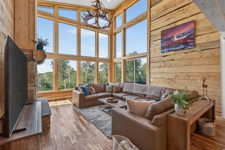 Vaulted living area featuring extensive natural wood plank wall finishes and wood-finish flooring