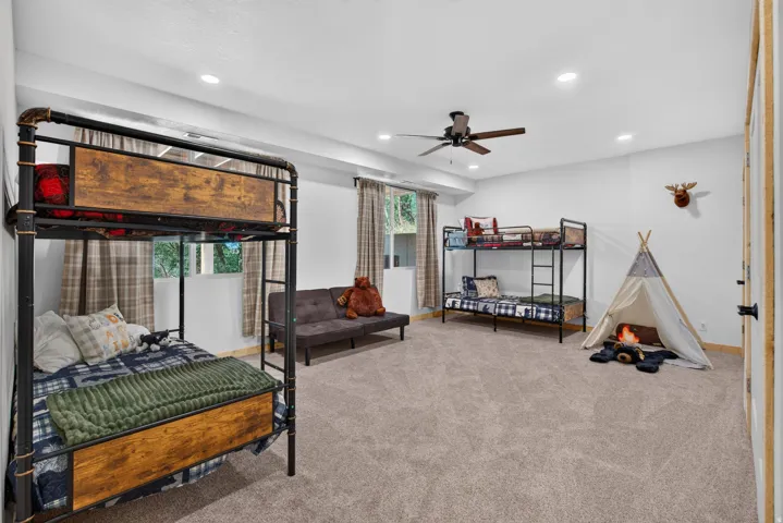 Spacious room featuring neutral carpeting, recessed lighting, a ceiling fan, and window with plaid drapery