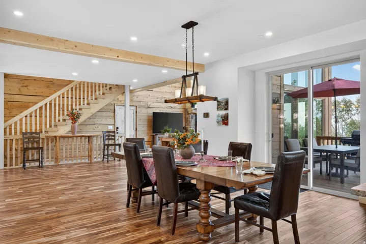 Spacious dining area featuring wood-finish flooring, a rustic wood chandelier, and recessed lighting
