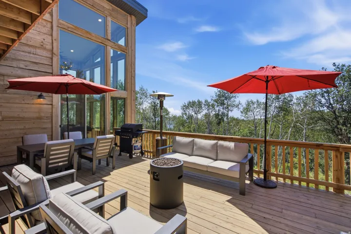 Spacious wood deck featuring wood railings and natural tree surroundings
