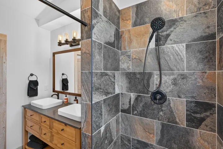 Shower stall with varied slate-style tiling and a dark bronze showerhead