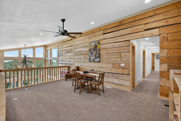 Loft area featuring plank wood walls, recessed lighting, and a ceiling fan