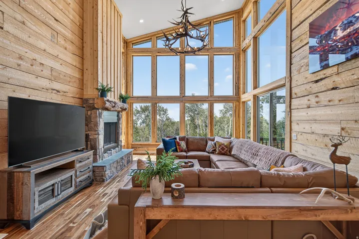 Two-story living area featuring extensive wood-finish wall paneling and flooring